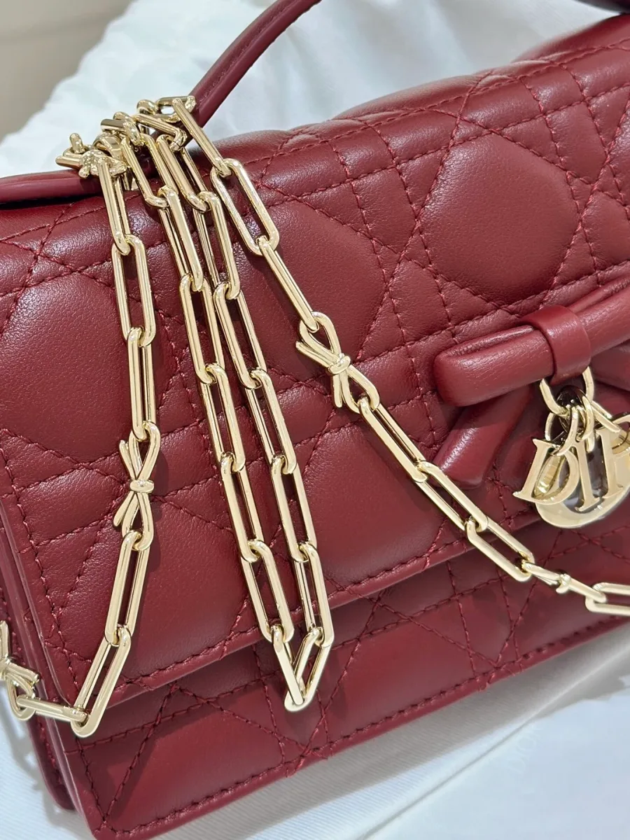 Бордовая сумка Dior WOC с золотистой цепочкой, сложенной на клапане