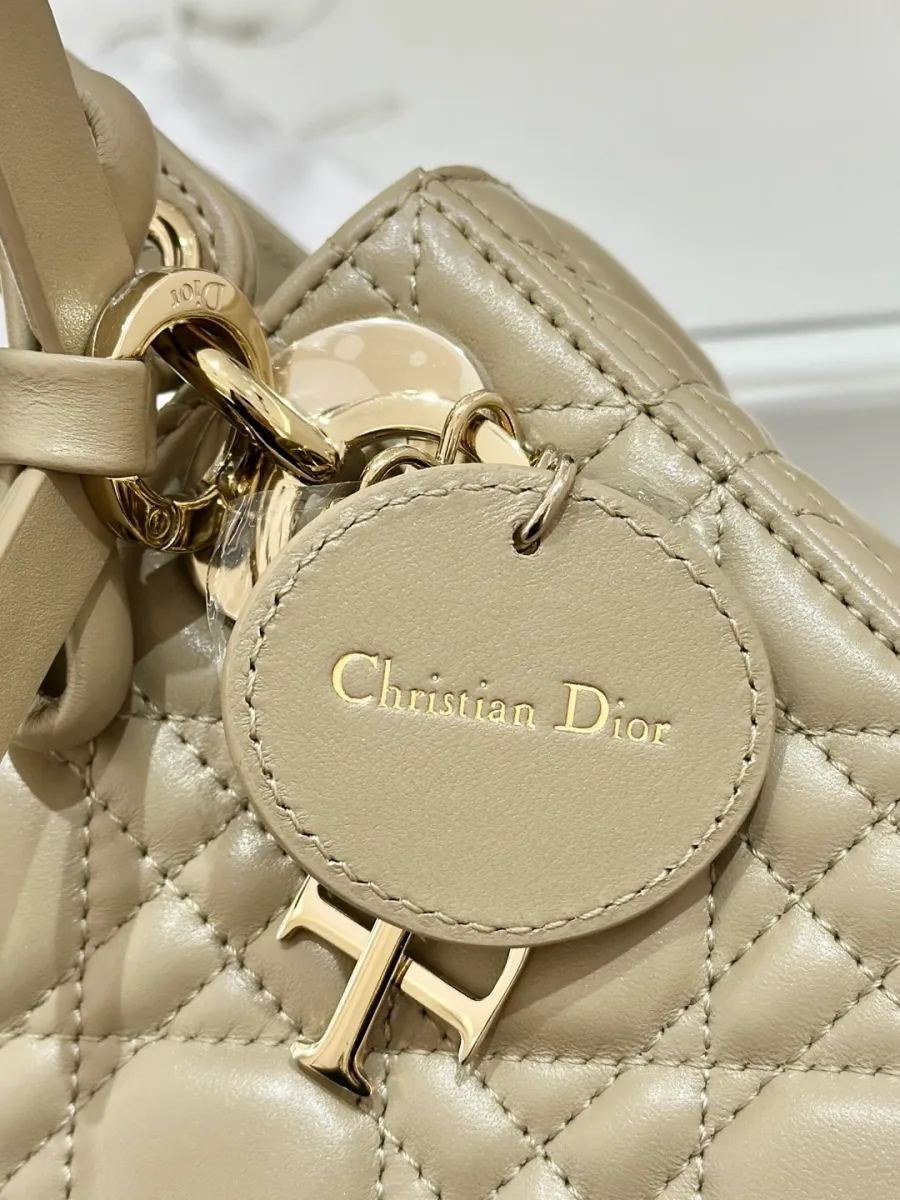 Крупный план круглой кожаной бирки с тиснением Christian Dior на сумке
