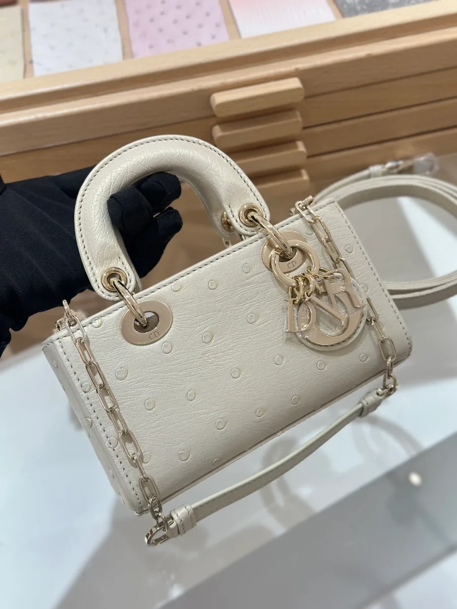 Бежевая сумка Lady D-Joy 16 из кожи страуса, вид спереди с ручками и подвеской DIOR