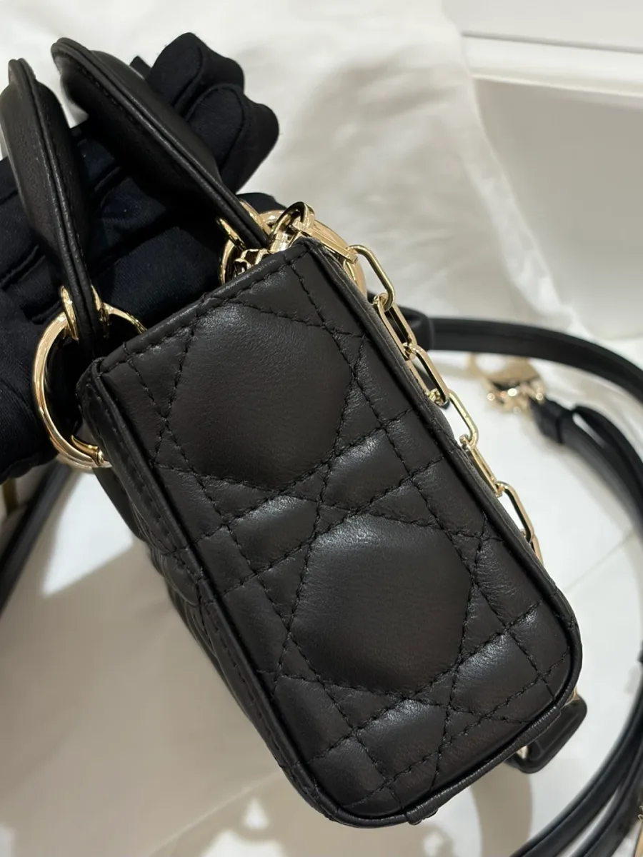 Боковая сторона черной стеганой сумки Dior Lady D-Joy, демонстрирующая ширину