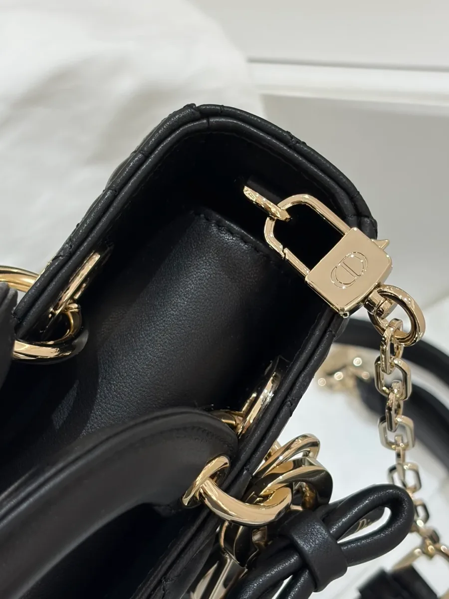Крупный план крепления плечевого ремня и золотистого карабина на сумке Dior
