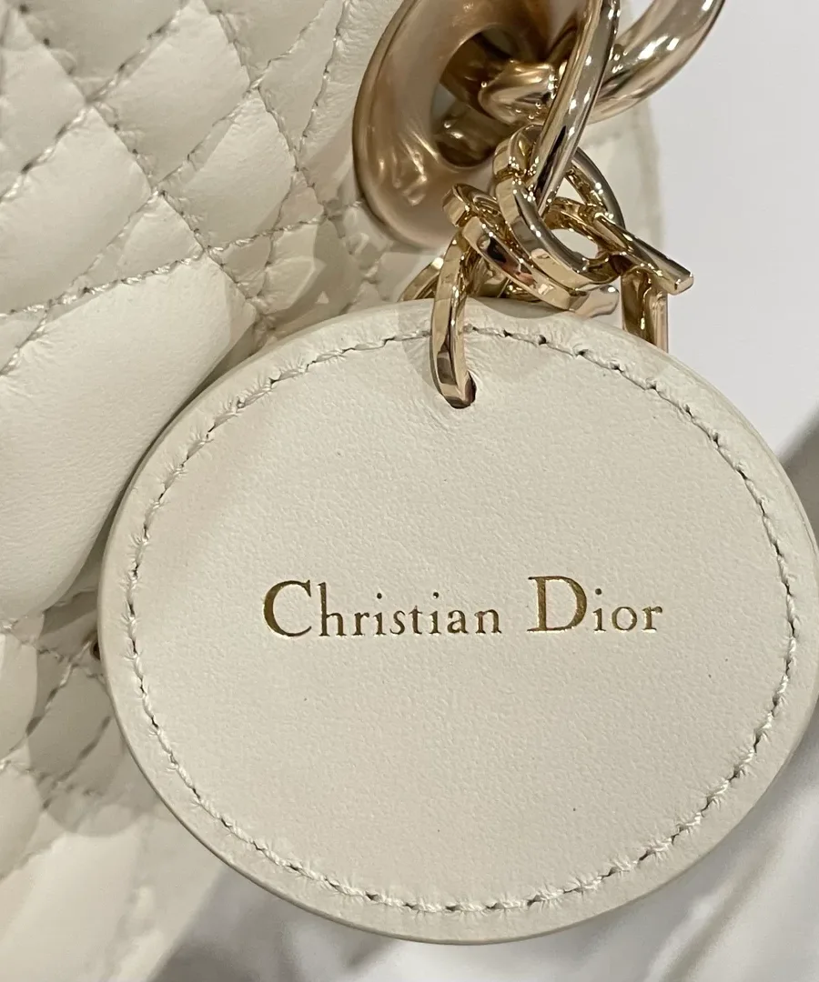 Крупный план кожаного круглого ярлыка с тиснением Christian Dior