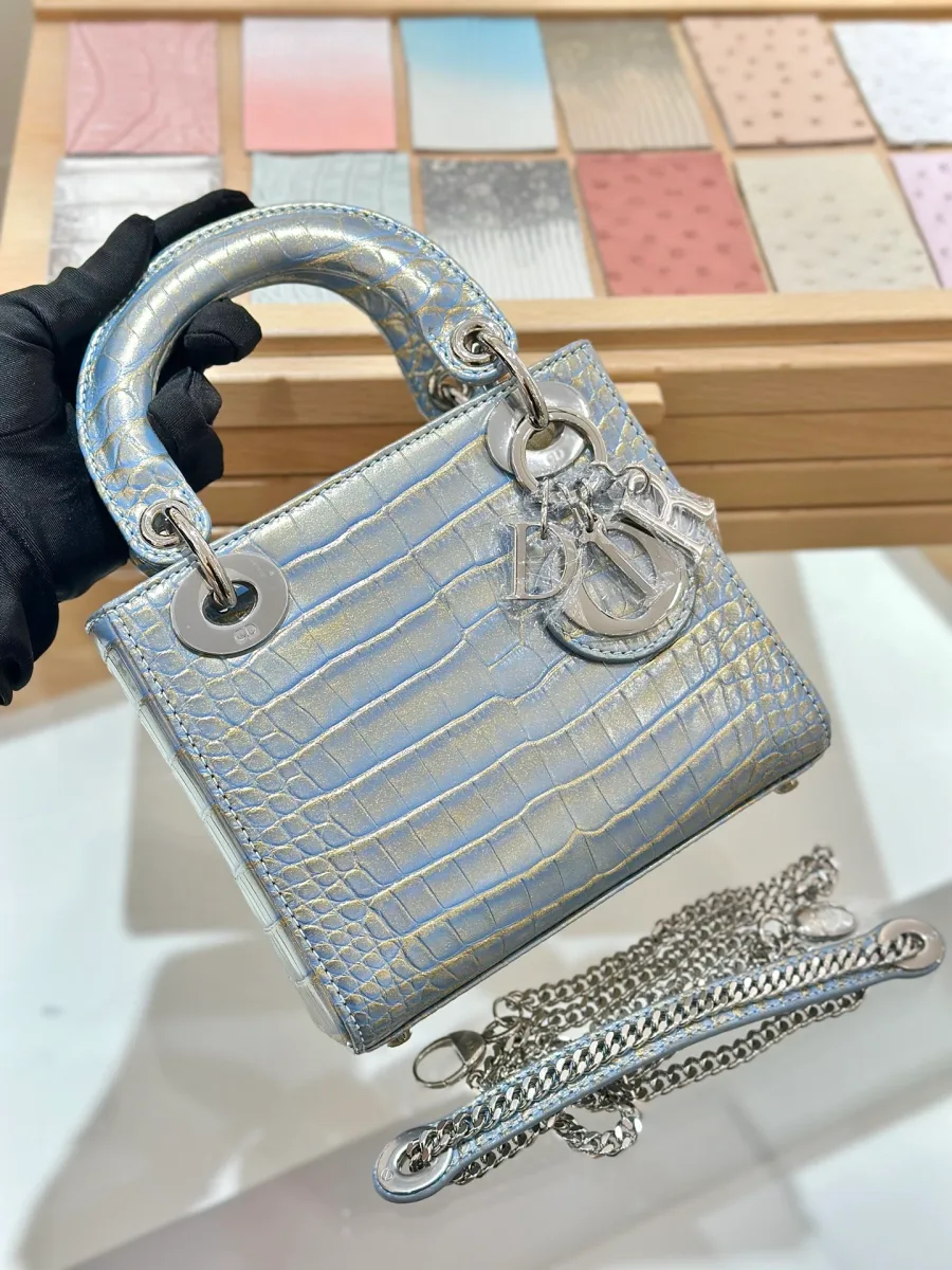 Голубая сумка Lady Dior 17 из кожи крокодила с серебристой фурнитурой, вид спереди в руке