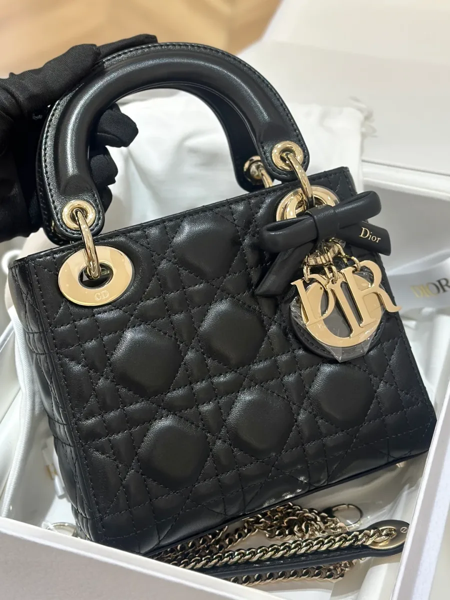 Черная стеганая сумка Lady Dior с золотистой фурнитурой и подвеской-бантом, вид спереди