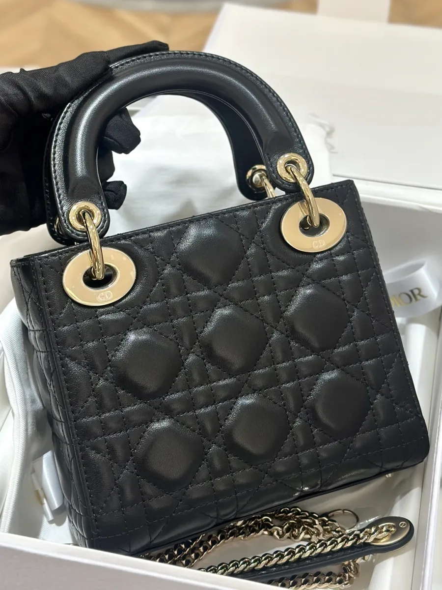 Черная кожаная сумка Lady Dior с узором Cannage и ручками, вид спереди в коробке