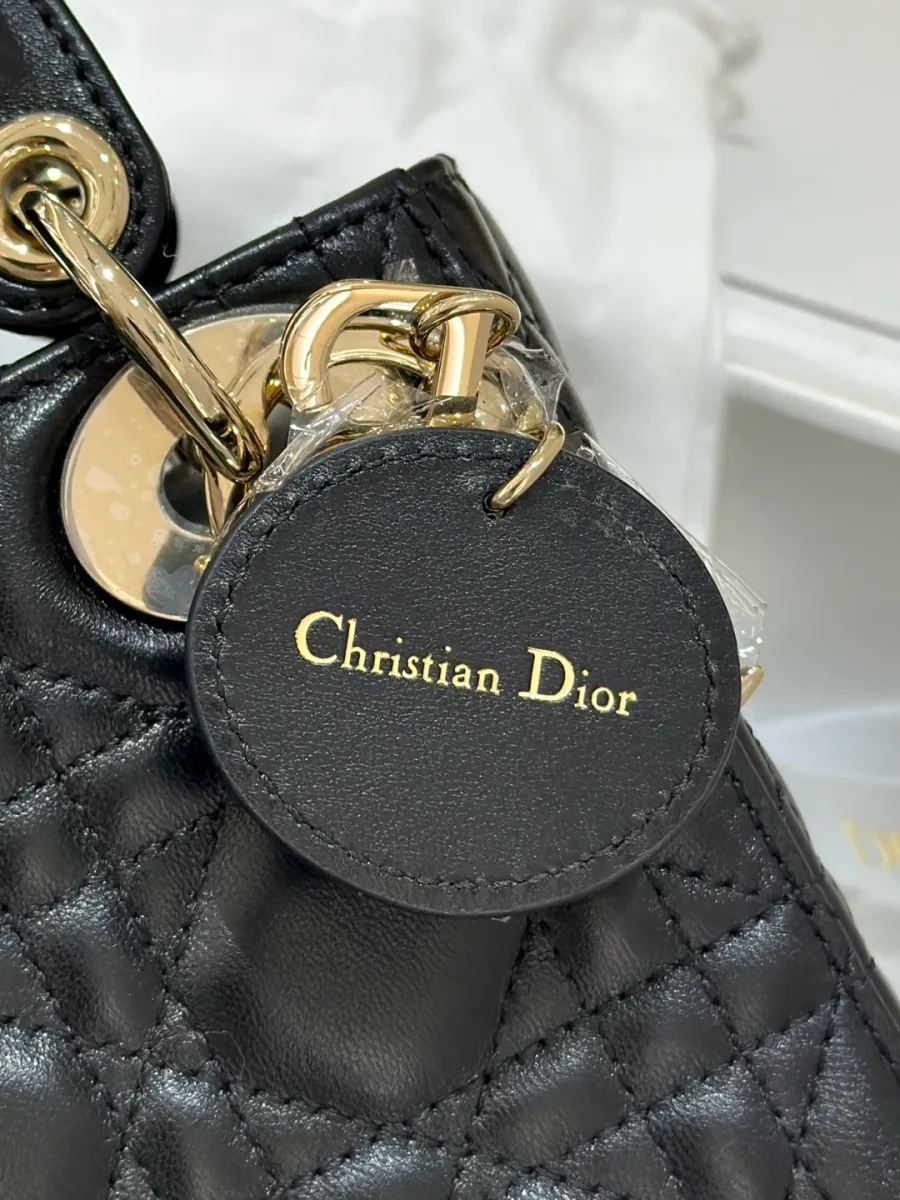 Крупный план кожаного ярлыка с тиснением Christian Dior на обратной стороне подвески