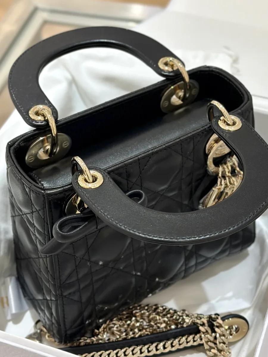 Вид сверху на открытую черную сумку Lady Dior с ручками и внутренним отделением