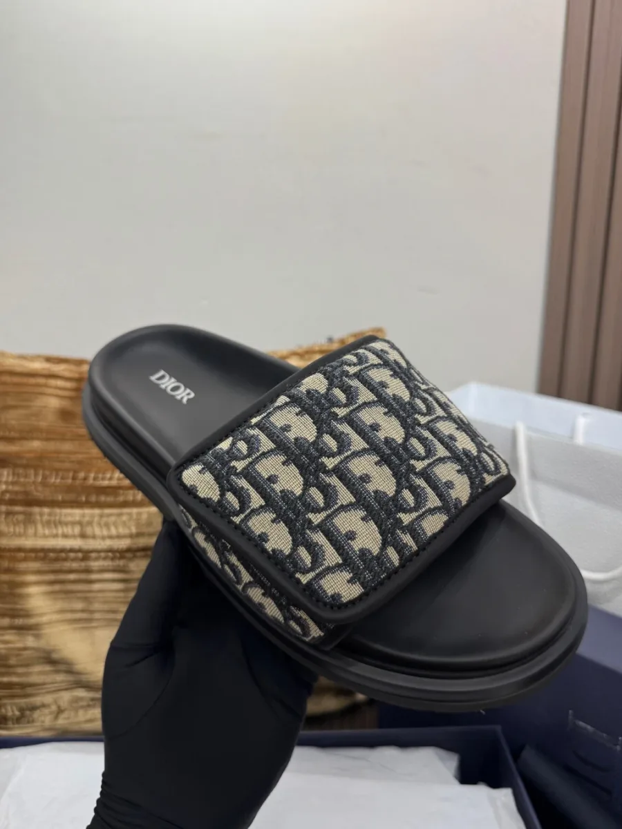 Шлёпанец Dior Oblique в руке, вид сверху на стельку и ремешок