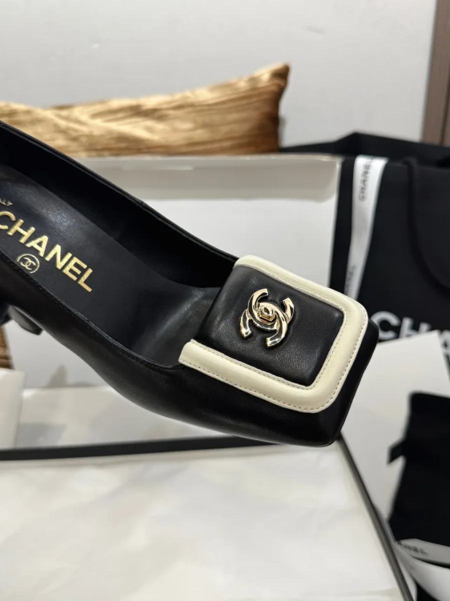 Верхняя часть чёрной туфли Chanel с декоративной пряжкой и золотистым логотипом