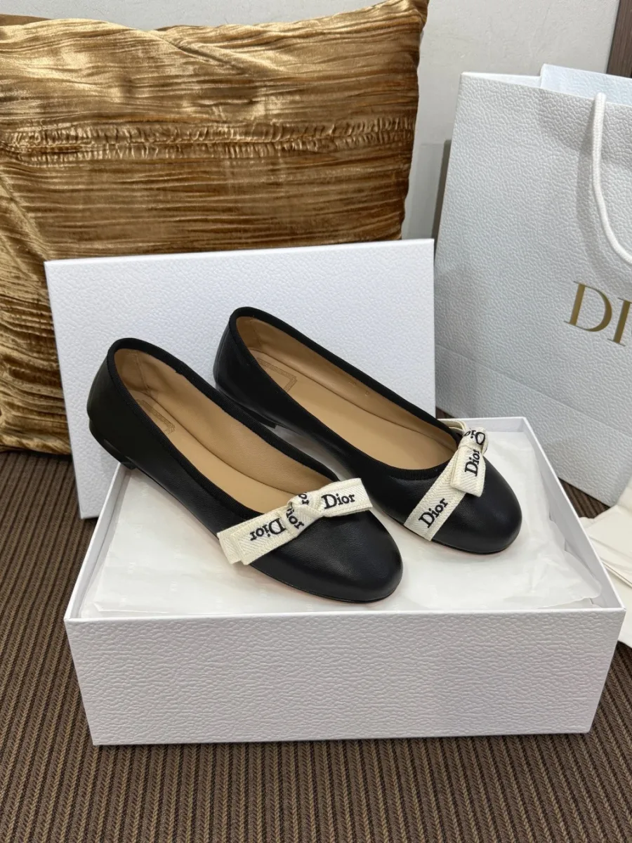 Чёрные балетки с лентой Dior на коробке, ракурс три четверти
