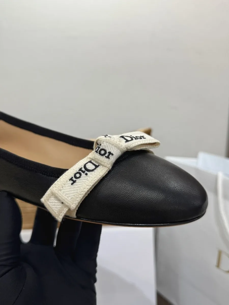 Крупный план мыска и вышитой ленты Dior на чёрной балетке