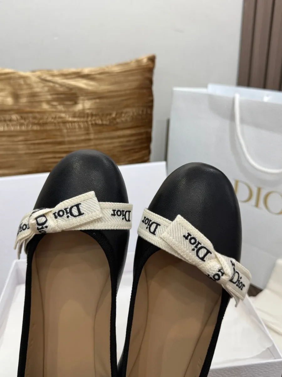 Крупный план мысков чёрных балеток с вышитой лентой Dior