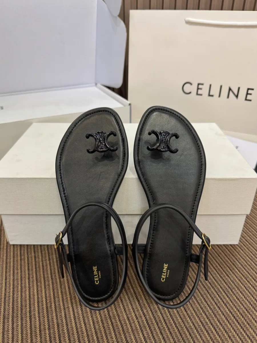 Чёрные кожаные сандалии Celine Triomphe сверху на обувной коробке рядом с фирменным пакетом