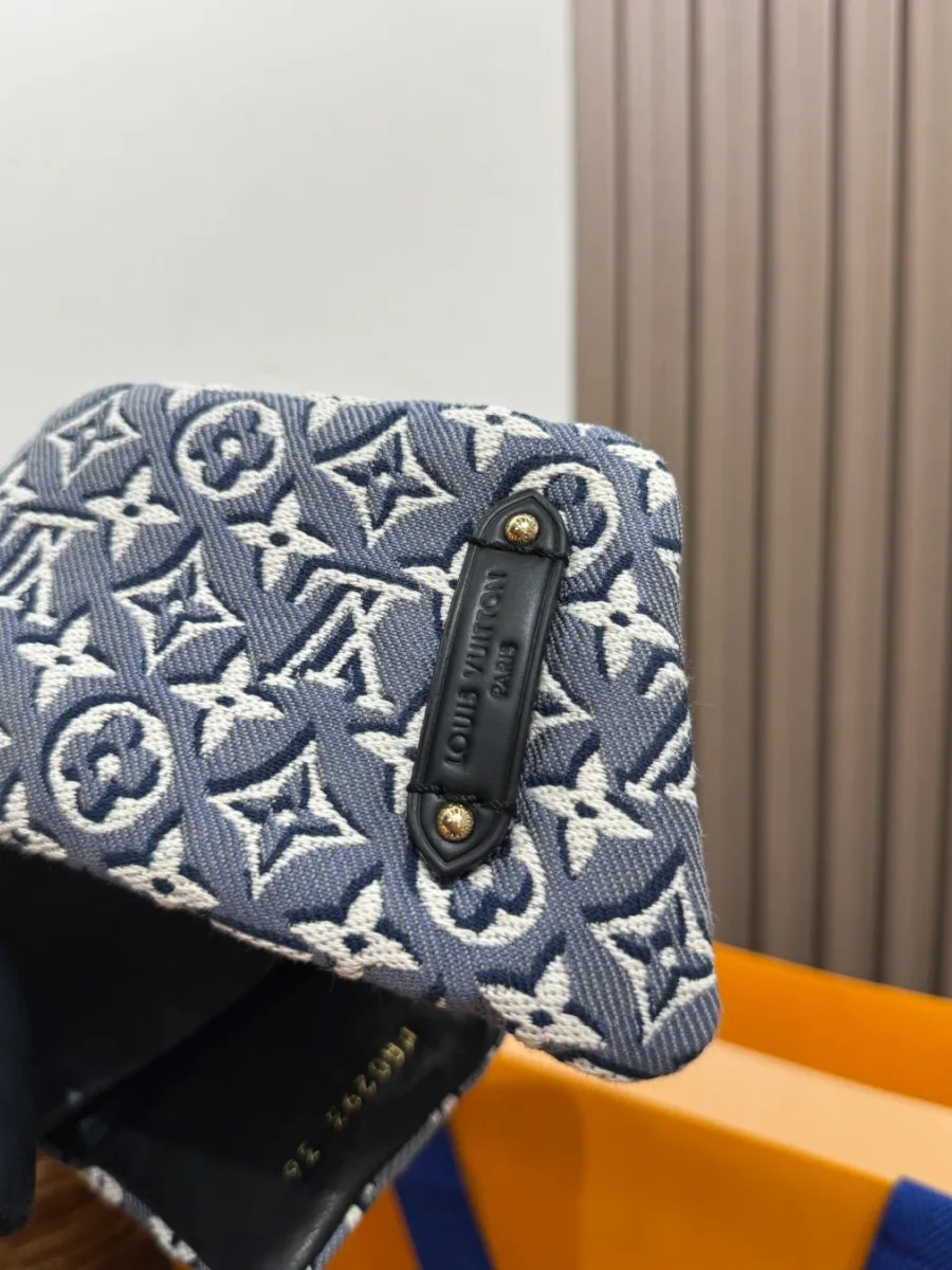 Деталь кожаной планки с тиснением Louis Vuitton на джинсовом ремешке