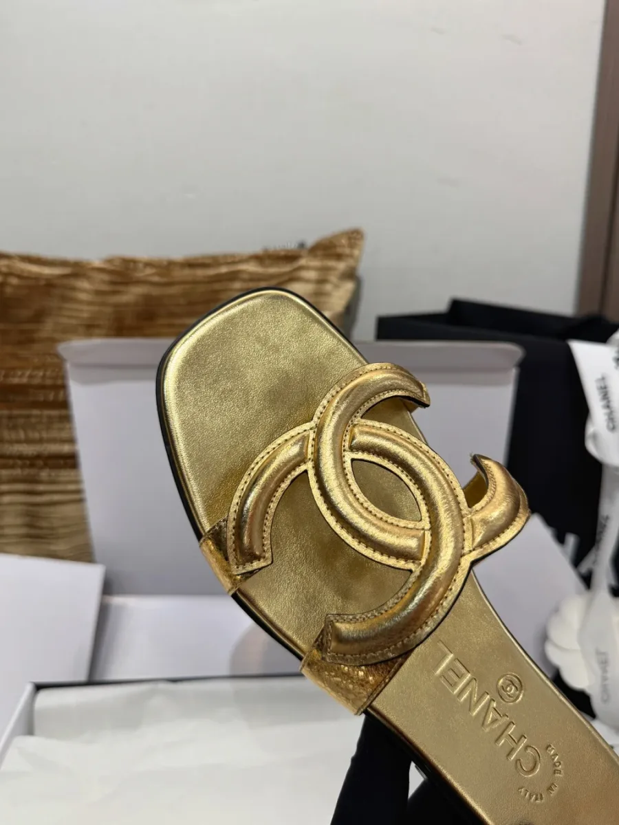 Золотистый шлёпанец в руке, вид сверху на стельку с тиснением Chanel