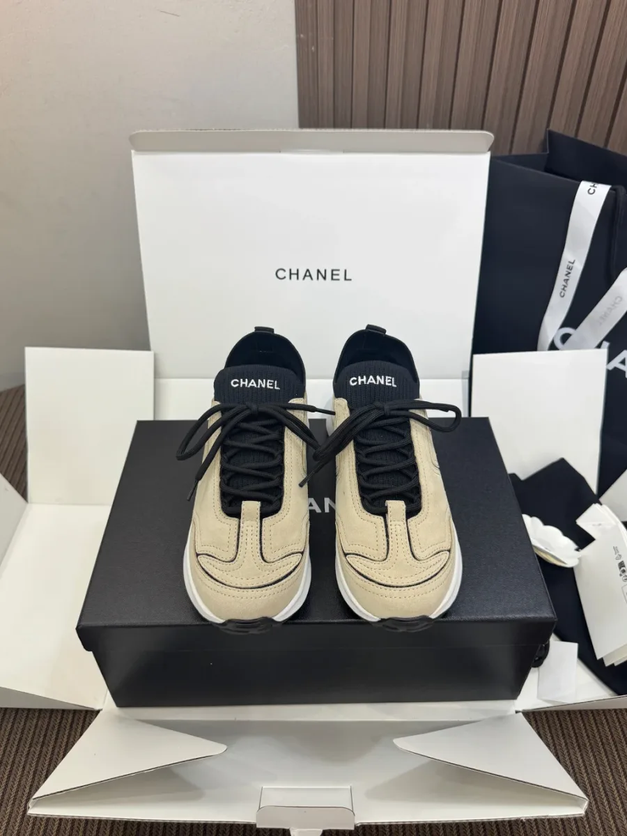 Бежево-чёрные кроссовки Chanel с эластичным носком на коробке, вид спереди