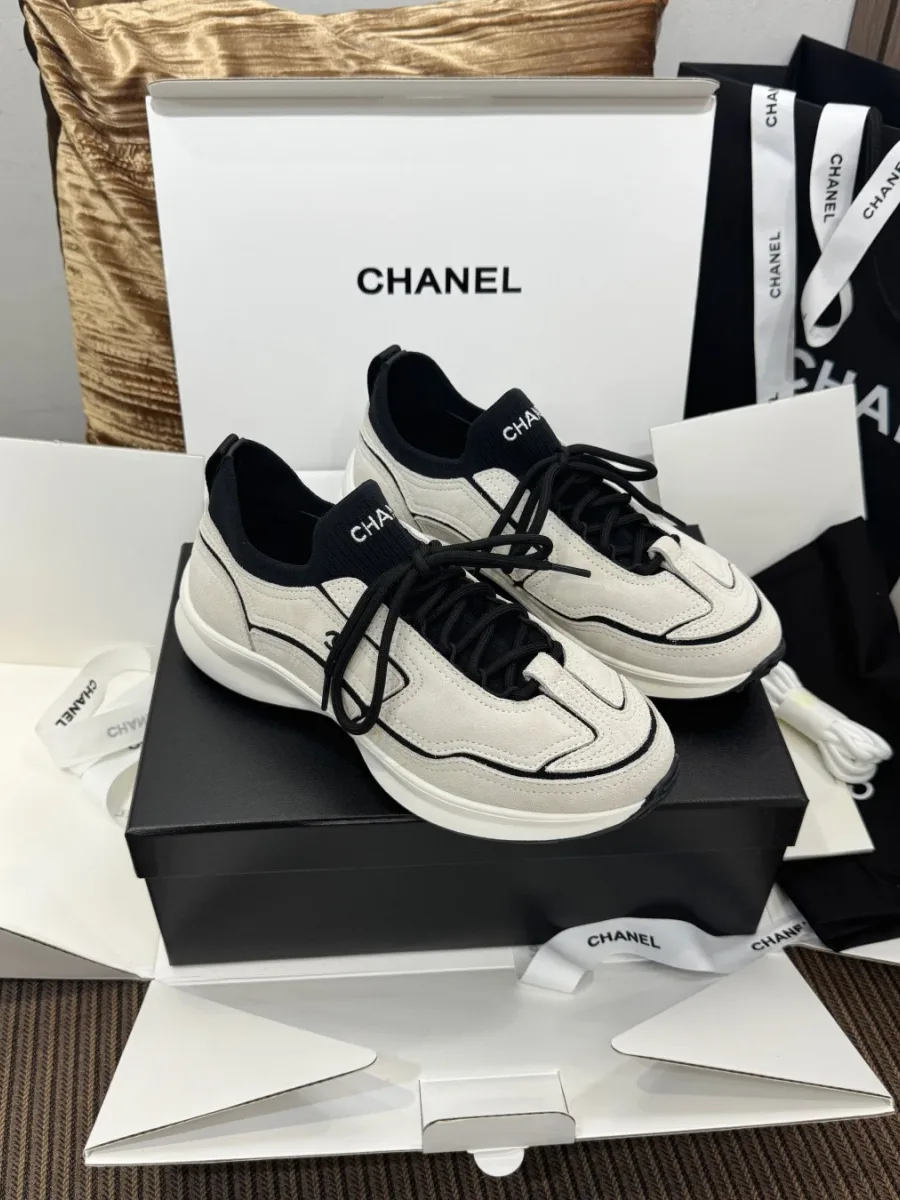 Кроссовки Chanel черно-белого цвета, ракурс три четверти на коробке