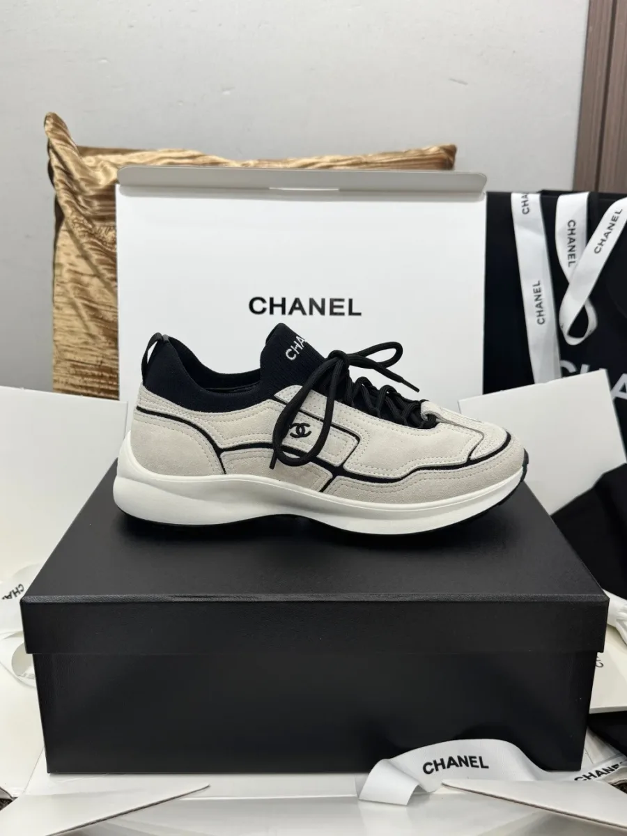 Черно-белый кроссовок Chanel, вид сбоку с логотипом CC на коробке