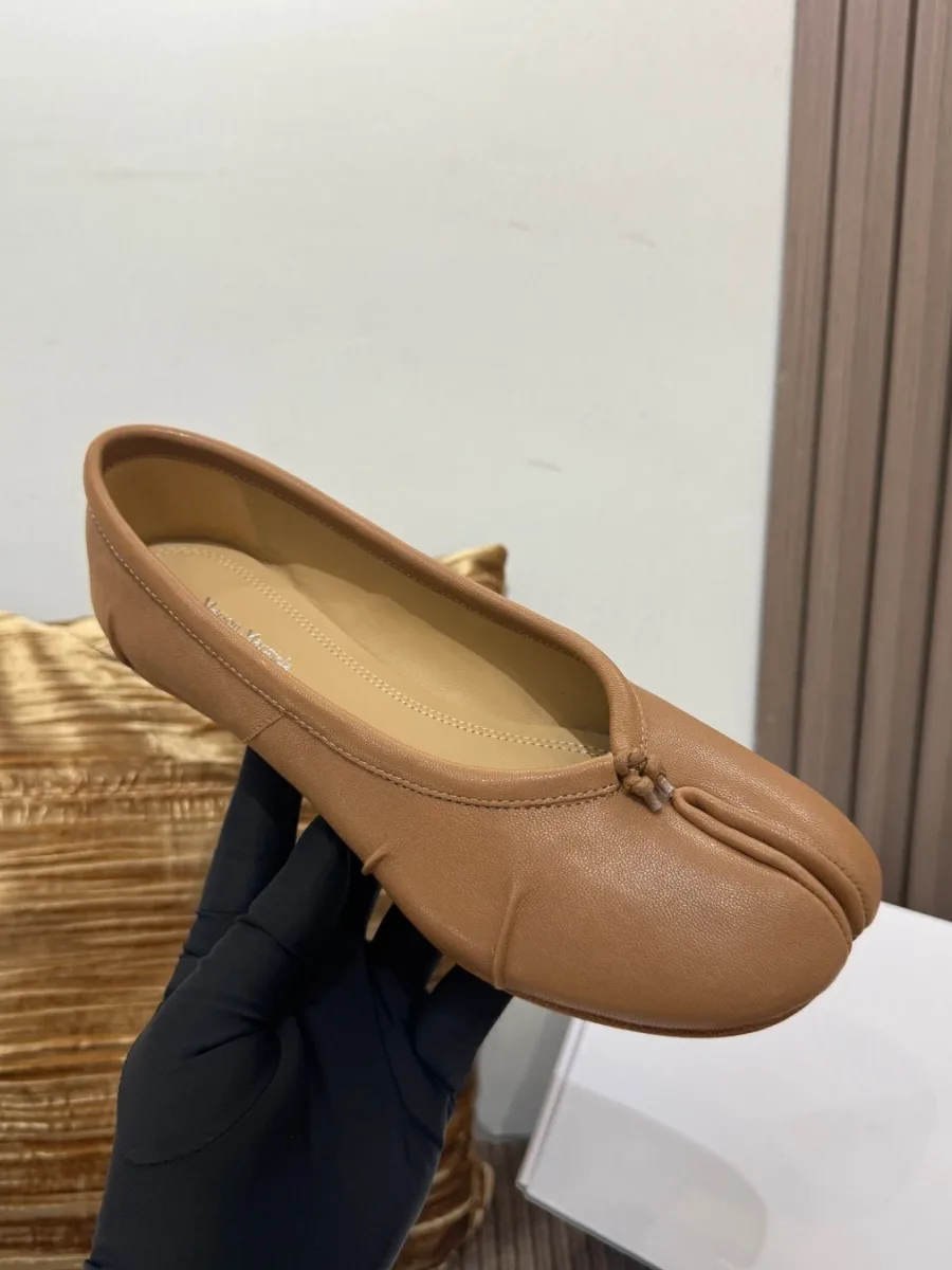 Бежевая балетка Tabi из кожи в руке, ракурс сверху и спереди