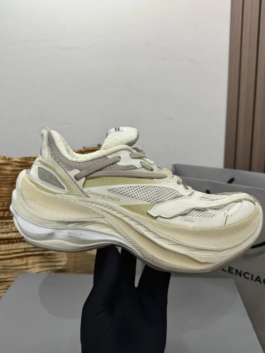 Бежевый кроссовок Balenciaga Jet в руке, вид сбоку на изогнутую подошву