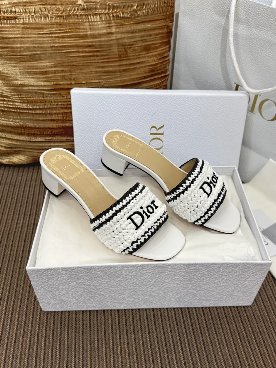 Пара белых шлёпанцев на каблуке с чёрным логотипом Dior, ракурс три четверти