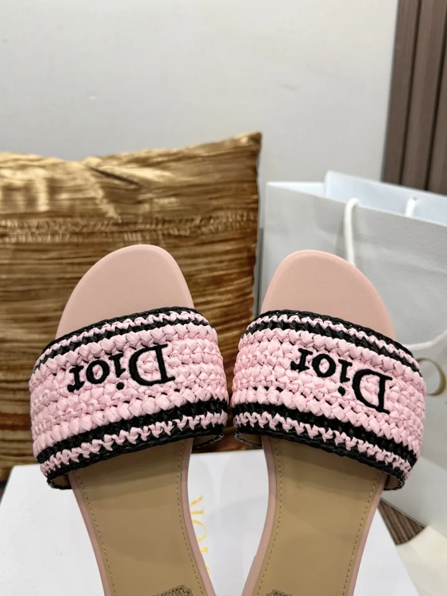 Крупный план плетёной перемычки розового цвета с вышивкой Dior и тёмным кантом