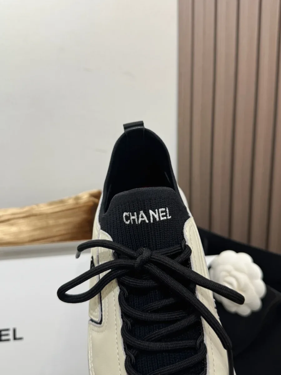 Крупный план язычка из чёрного трикотажа с белой надписью CHANEL