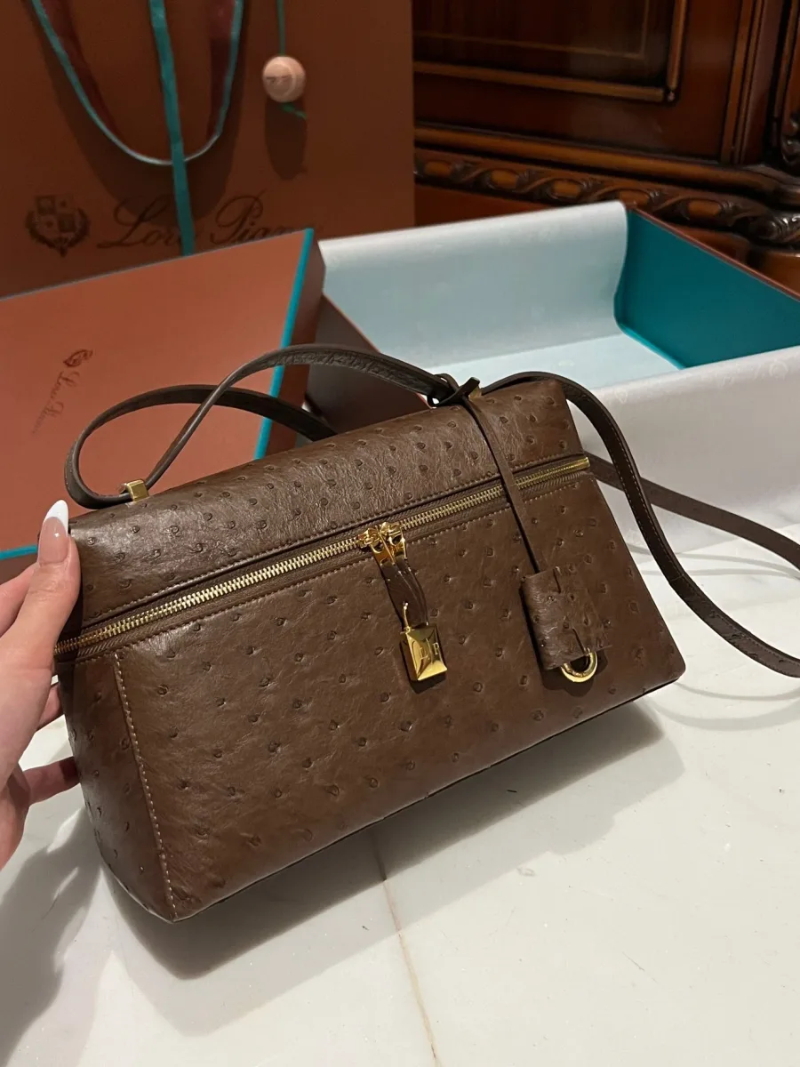 Сумка Extra Bag L27 из коричневой кожи страуса в руке, вид спереди