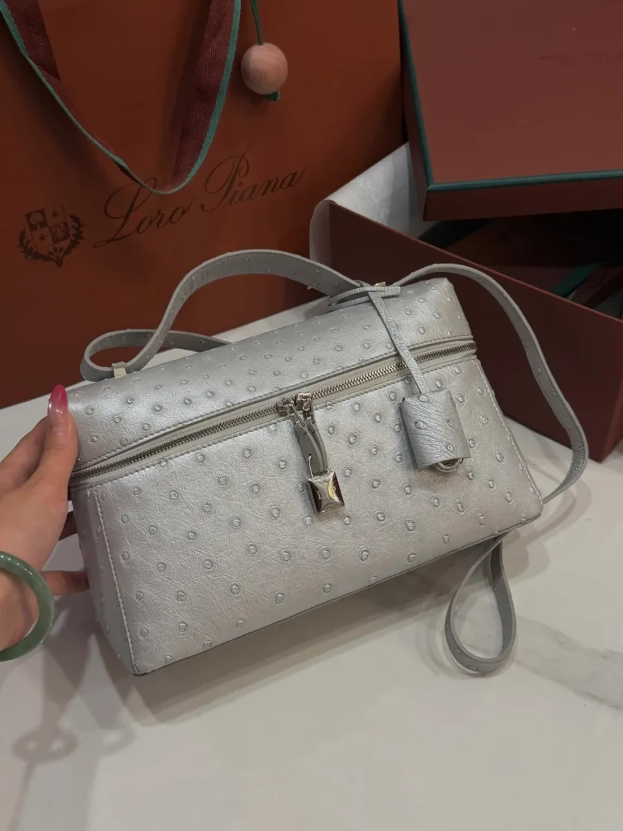Сумка Extra Bag L27 в руке, ракурс три четверти с брелоком