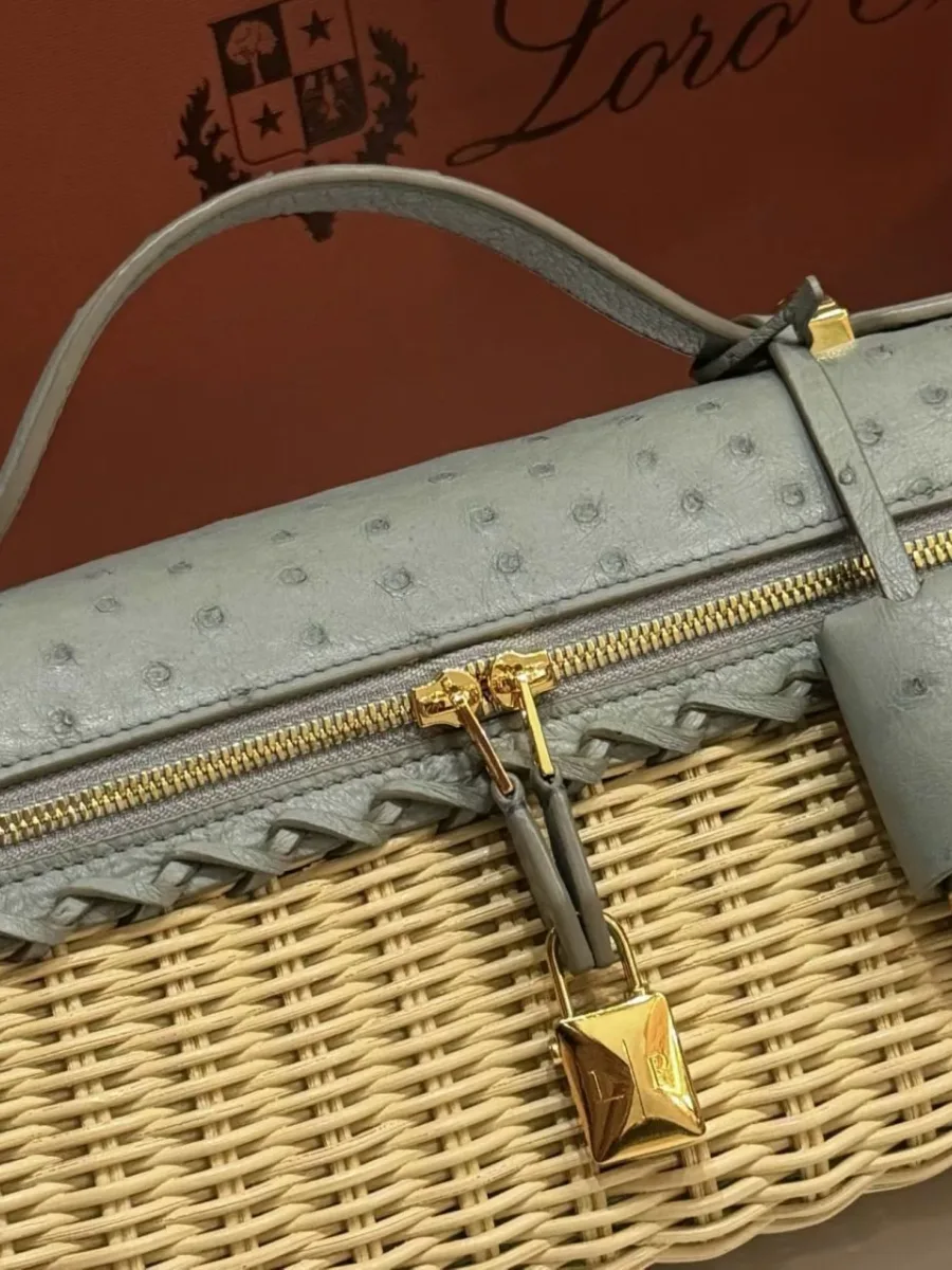 Крупный план верха сумки с круговой молнией и золотистым замком-брелоком