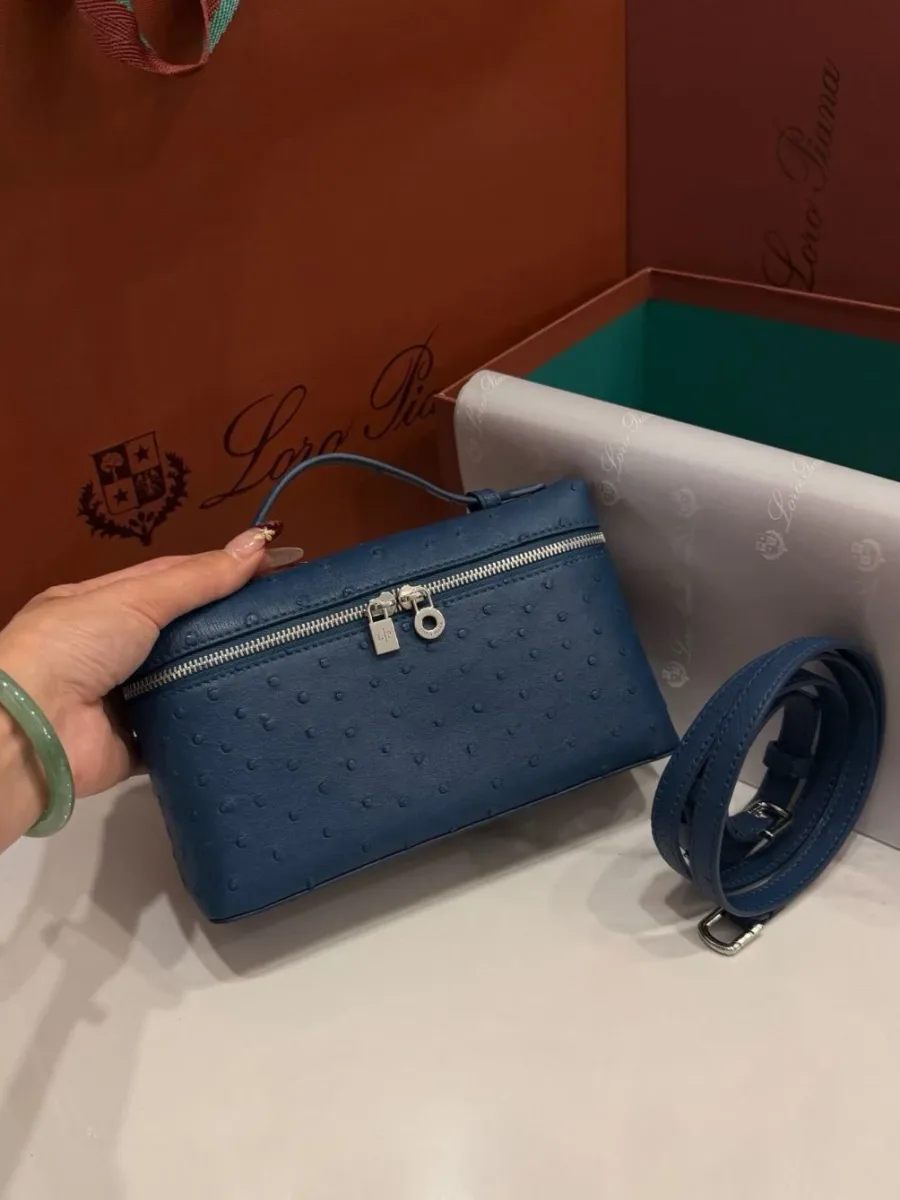 Синяя сумка Extra Pocket L19 в руке, вид спереди с ремнем