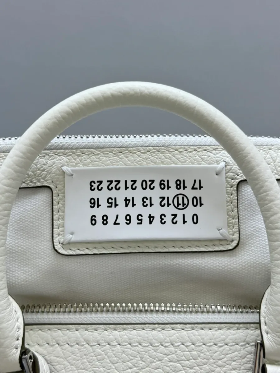 Текстильный верх сумки с фирменной нашивкой Maison Margiela и кожаной ручкой
