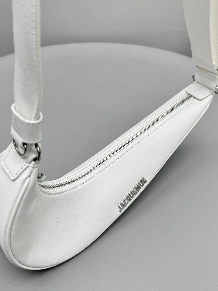 Белая сумка Le Swoosh на плечо, ракурс сверху на застежку-молнию и ремень