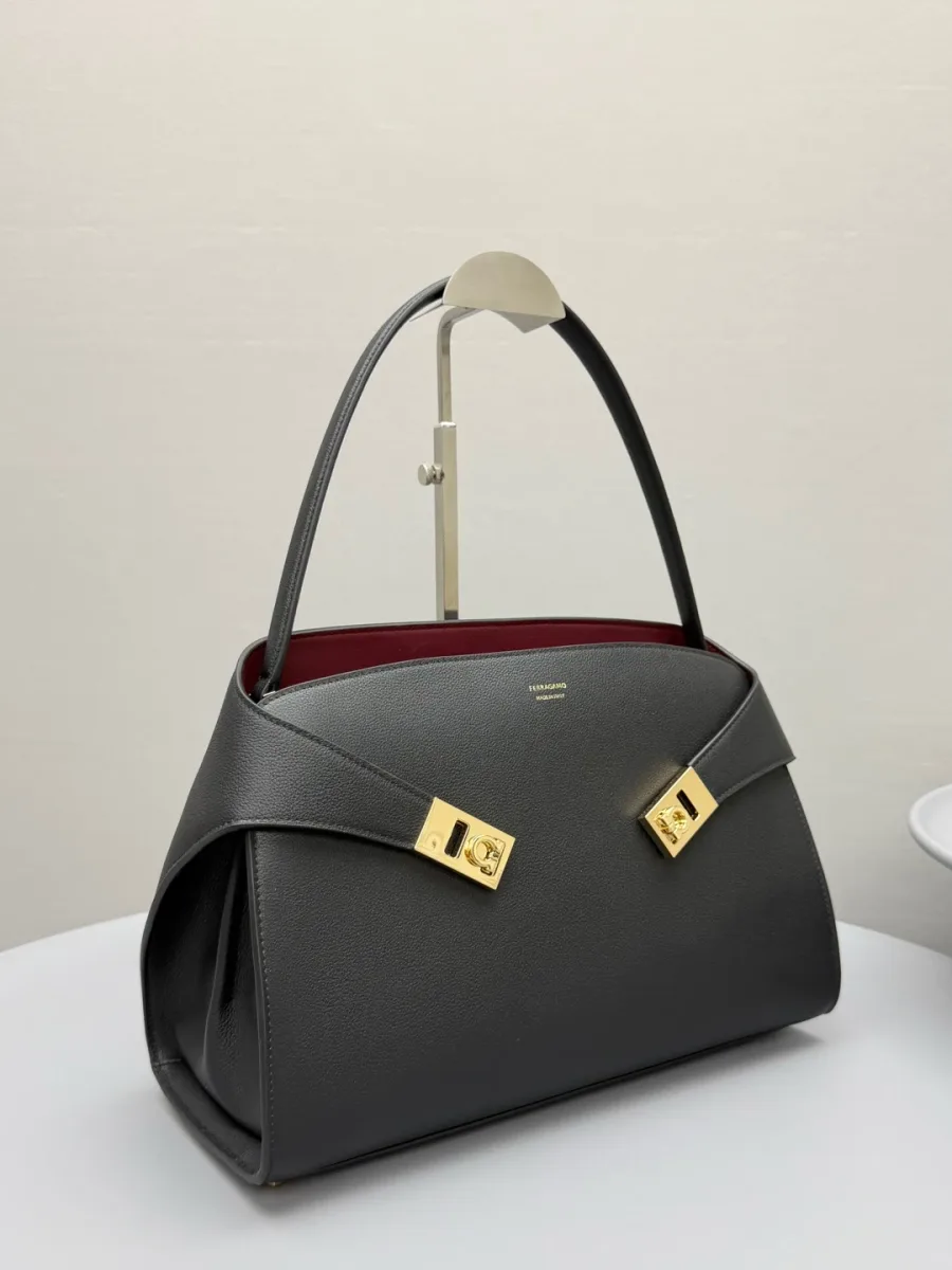 Чёрная сумка Ferragamo Hug Soft из фактурной кожи с золотистыми пряжками Gancini, ракурс три четверти