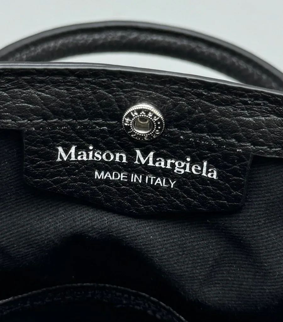 Крупный план серебристой заклёпки и тиснения Maison Margiela Made in Italy