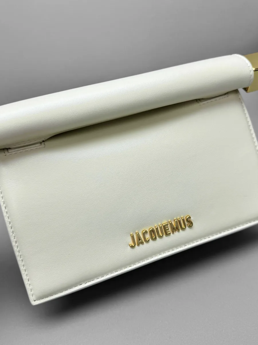 Крупный план передней панели с золотистым логотипом Jacquemus