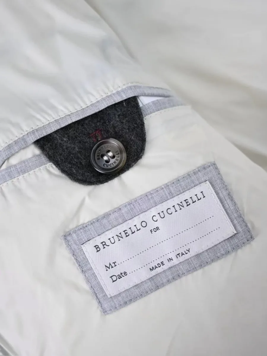 Внутренняя часть графитового пуховика Brunello Cucinelli, с белой подкладкой и вшитой маркировочной биркой