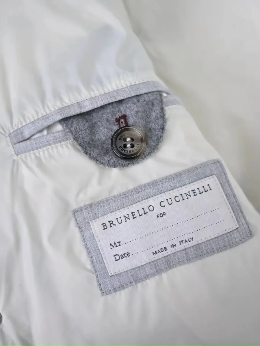 Светло-серый пуховик Brunello Cucinelli изнутри с белой подкладкой, внутренним карманом и биркой