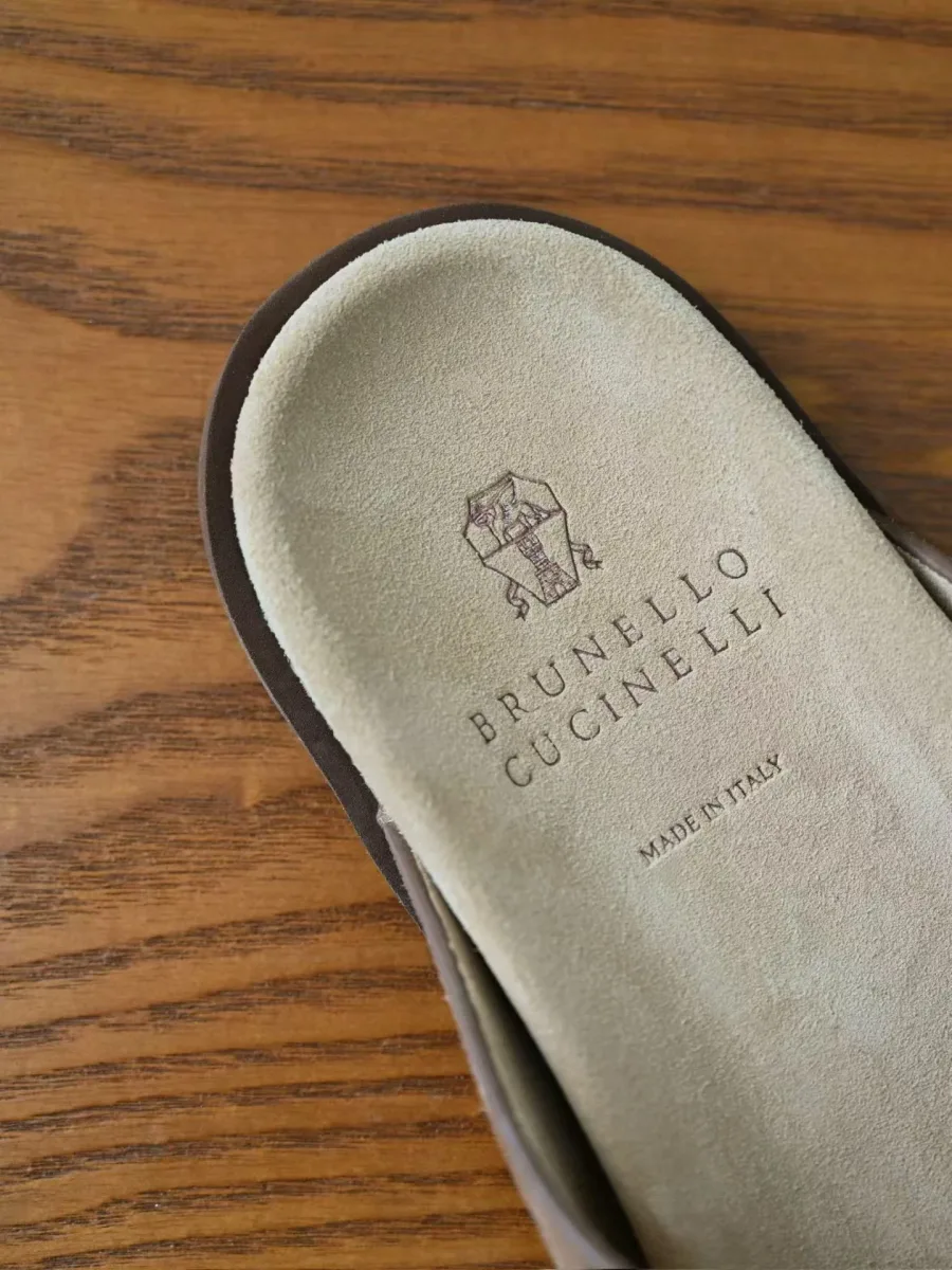 Стелька коричневого шлёпанца Brunello Cucinelli крупным планом, видны логотип и надпись