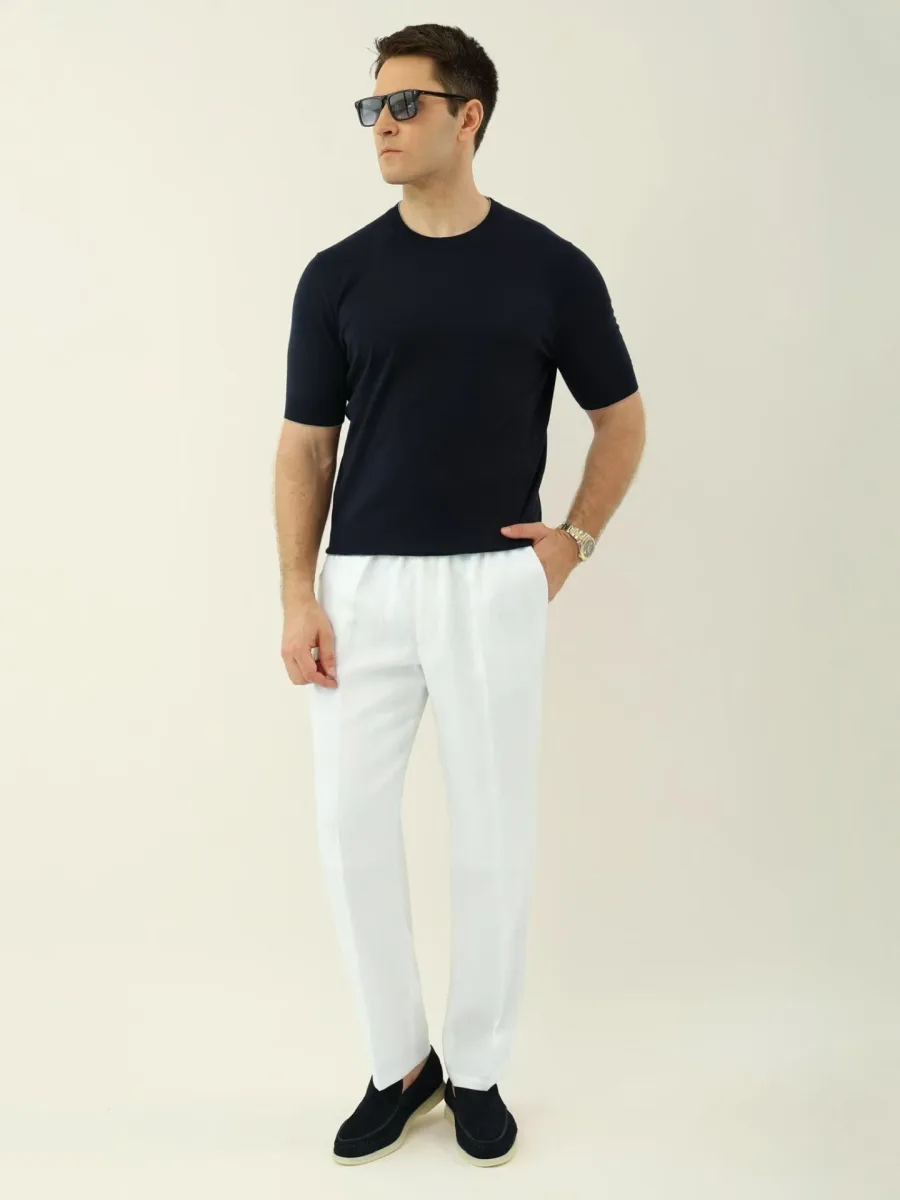 Белые льняные брюки Loro Piana на модели спереди, прямые штанины и эластичный пояс