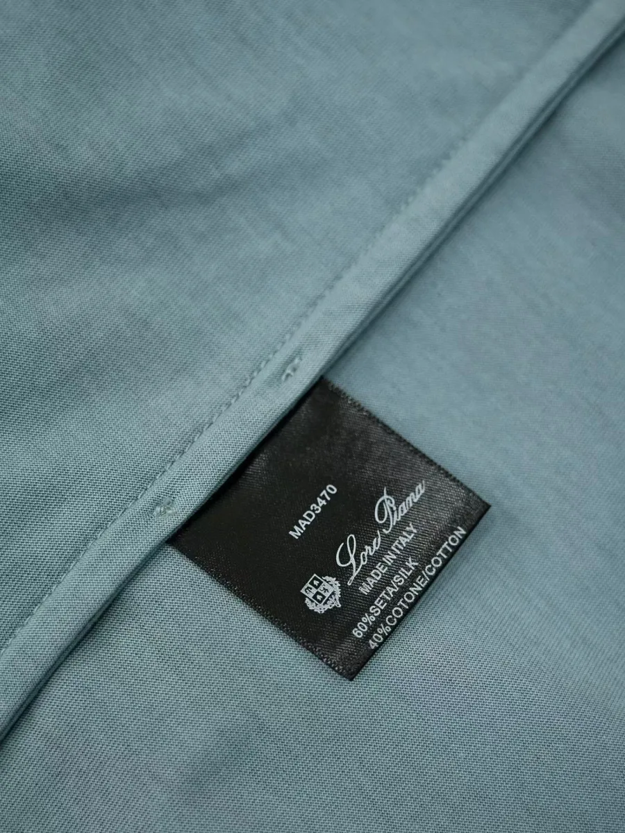 Синяя футболка Loro Piana, деталь нижнего края с внутренней чёрной этикеткой и швом
