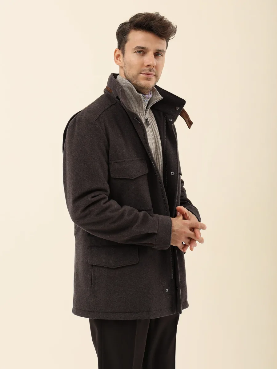 Тёмно-коричневая куртка на человеке сбоку с застёжкой спереди, накладными карманами и высоким воротником