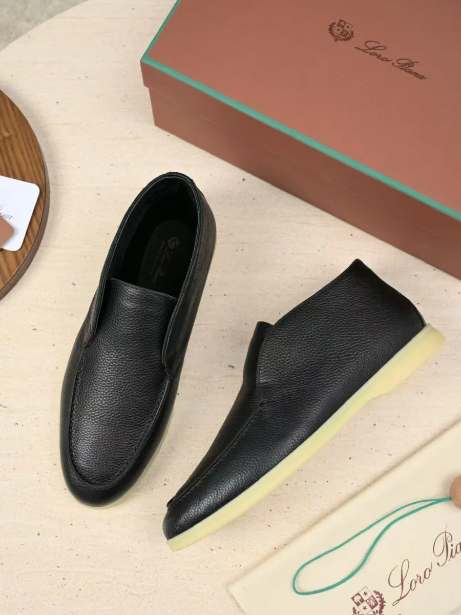 Пара графитовых кожаных лоферов Loro Piana под углом, с открытыми боковыми профилями и светлой подошвой