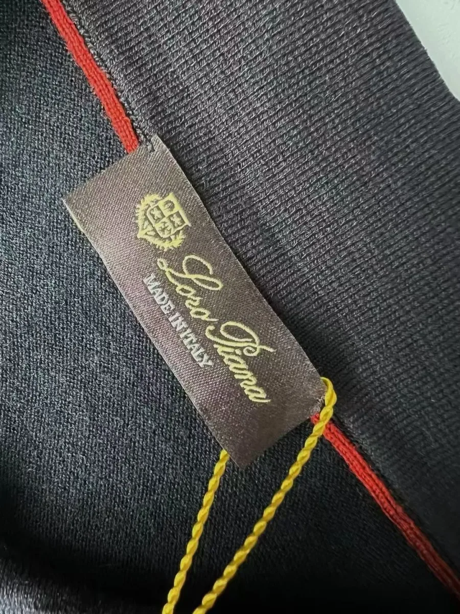 Чёрное мужское поло Loro Piana крупным планом с тканой биркой и вшитой этикеткой ухода
