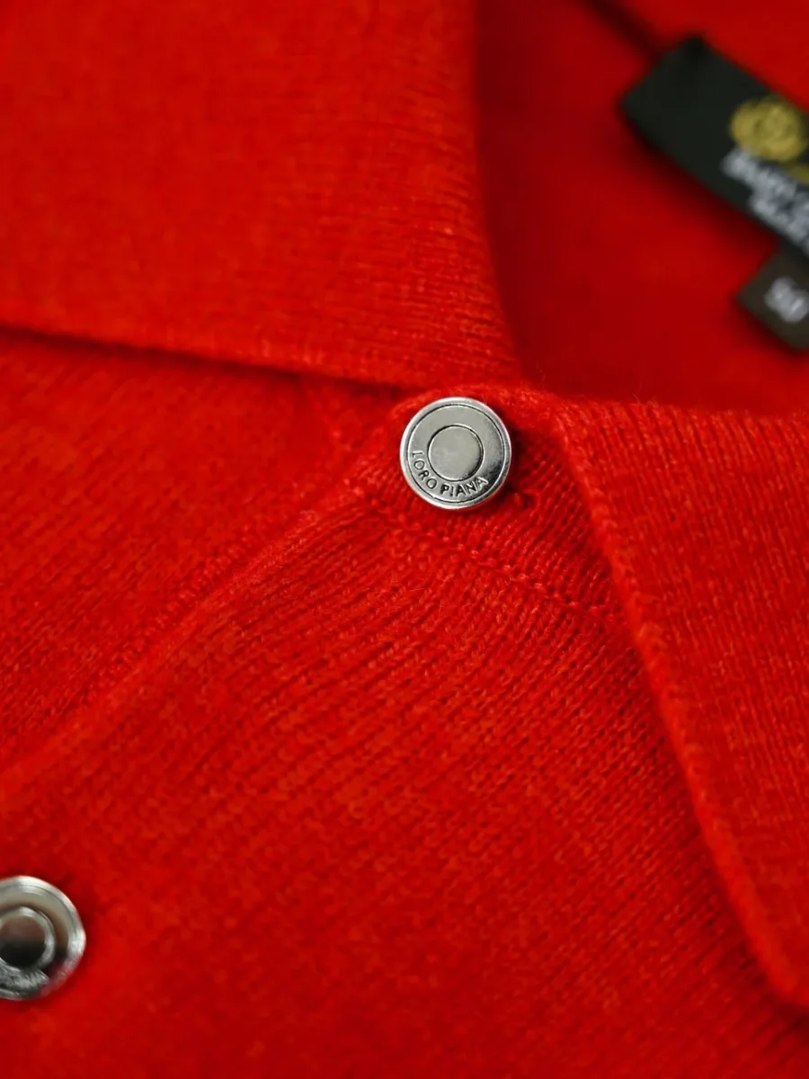 Деталь красного кашемирового поло с воротником и металлической пуговицей