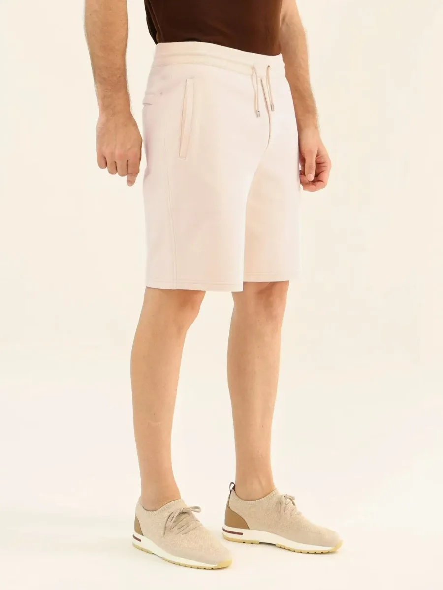 Молочные шорты Loro Piana на модели крупным планом спереди с двумя боковыми карманами