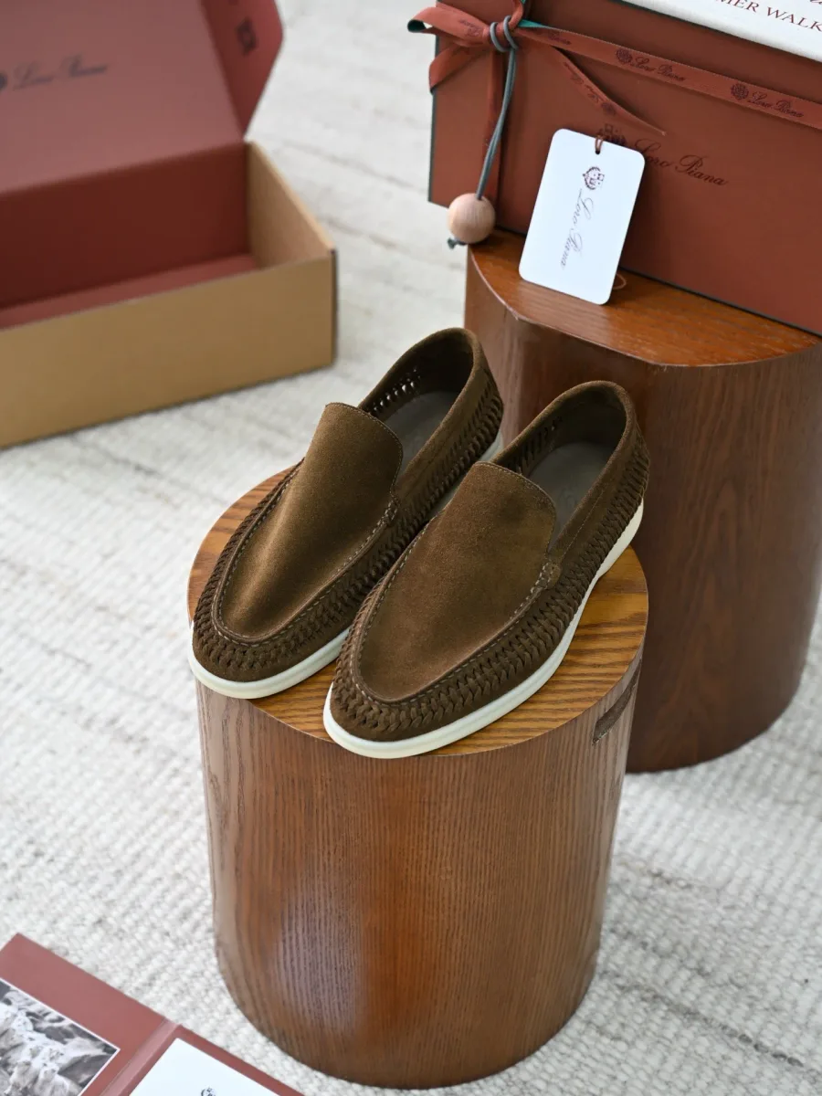 Пара оливково-коричневых замшевых лоферов в диагональном ракурсе с плетёными боковыми деталями