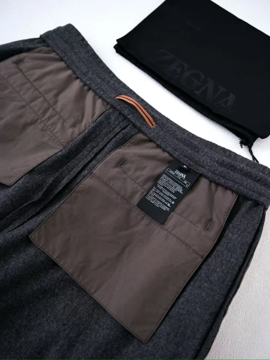 Графитовые брюки Zegna, вид изнутри с коричневой подкладкой, поясом и пришивной этикеткой