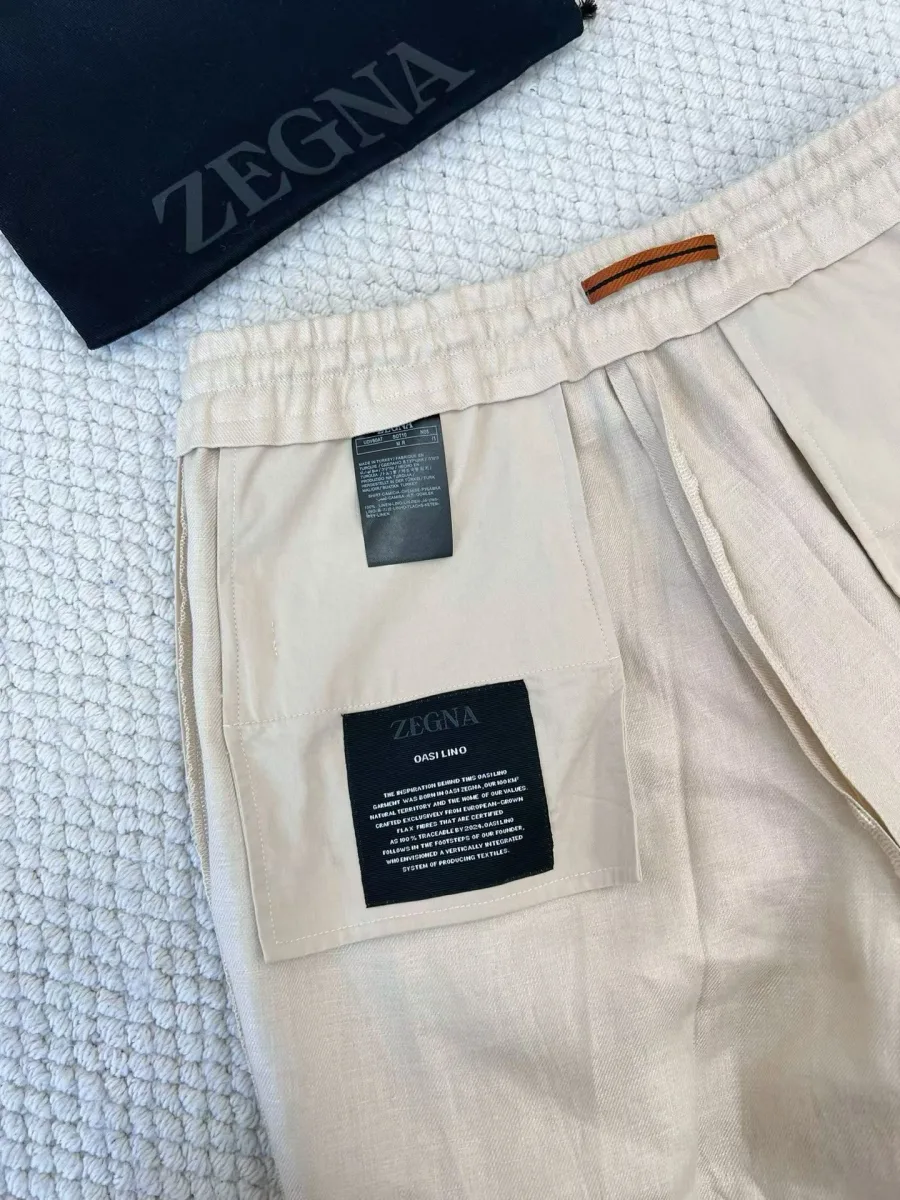 Бежевые льняные брюки Zegna крупным планом: эластичный пояс, карман и внутренние ярлыки