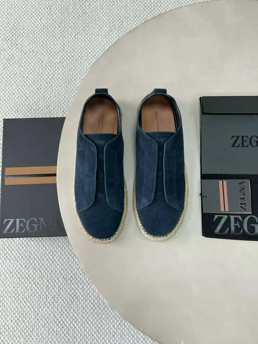 Пара эспадрилий Zegna Triple Stitch светло-синего цвета сверху, видны кожаные вставки и открытые носки